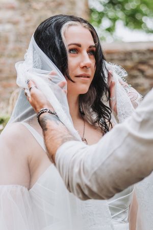 Closeup portrait of bride as the groom is lifting her veil during an intimate alternative wedding ceremony in Noord Holland