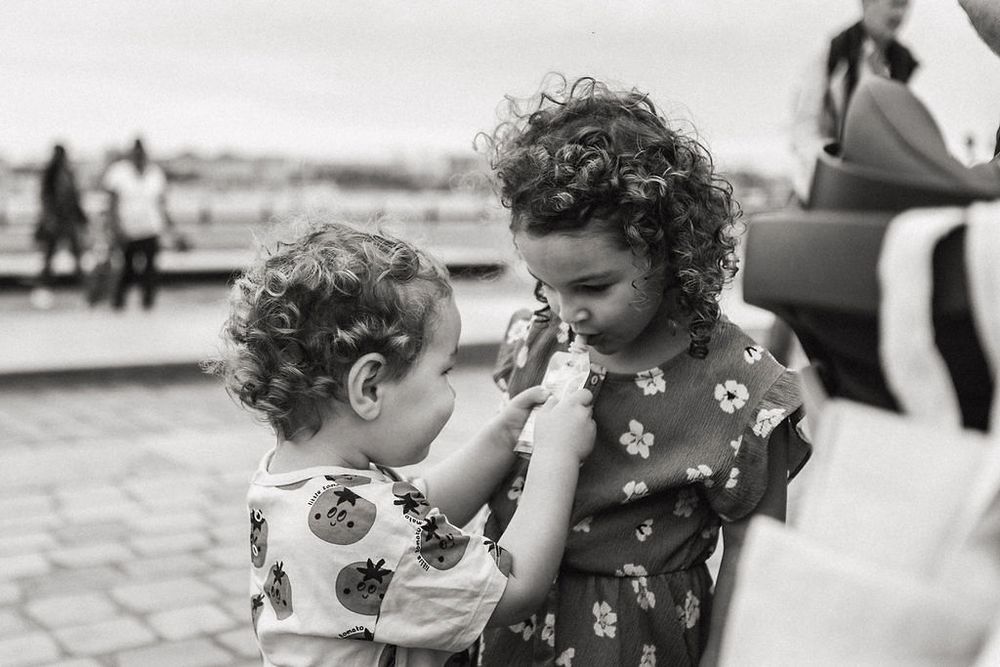 A touching black and white moment between two people sharing laughter outdoors.