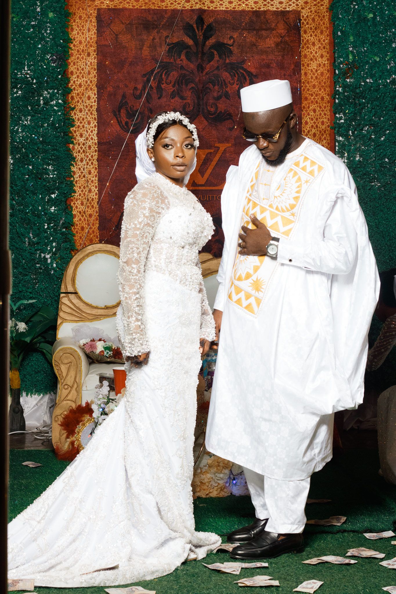 Traditional wedding ceremony featuring couple in white attire against ornate backdrop.