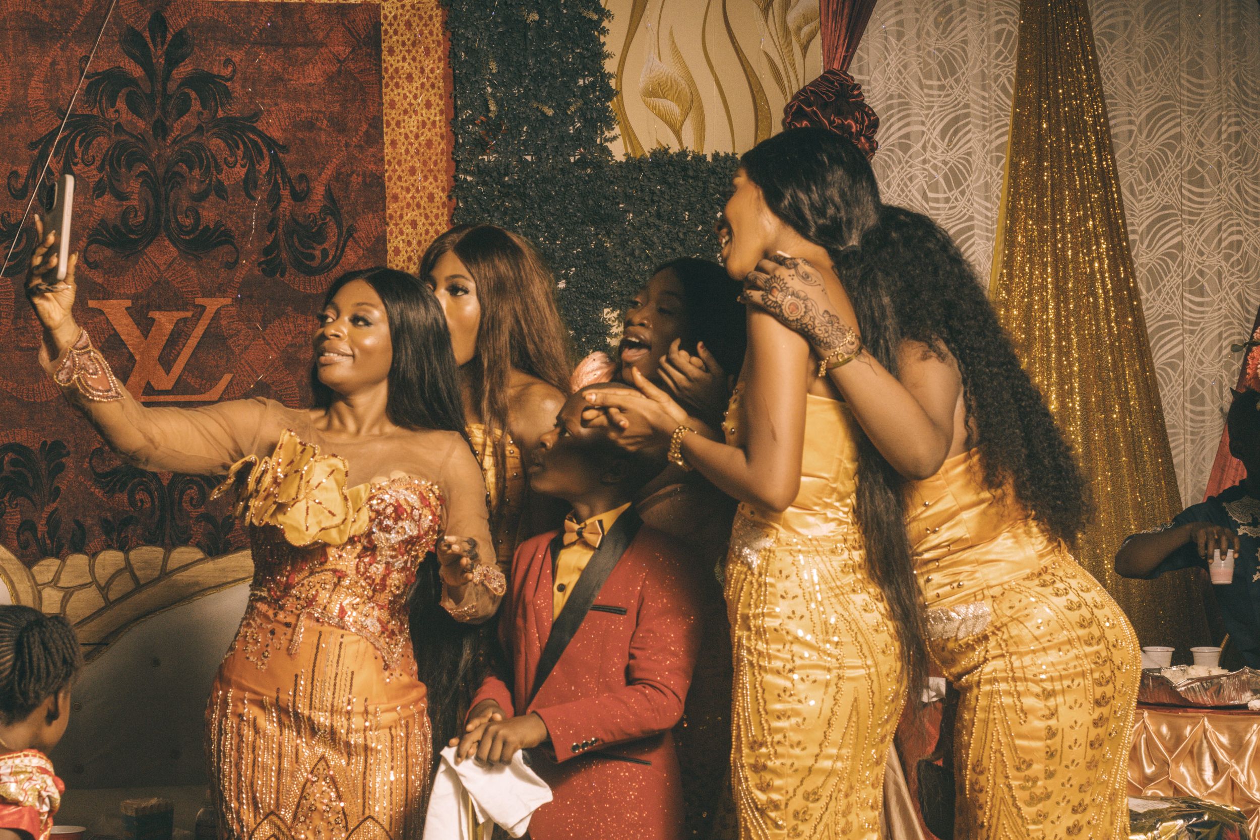 Celebration scene with people in formal attire dancing and taking photos.