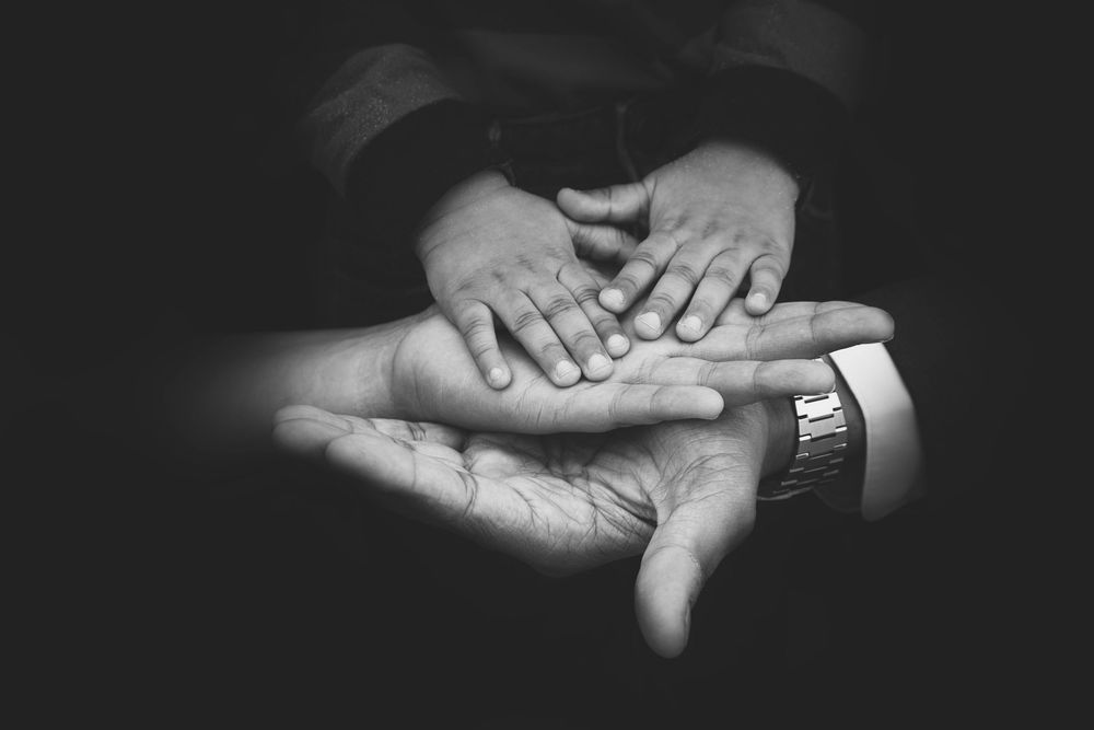 black and white photo of Dad's , Mum's and little boy's hands