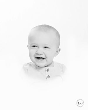 Black and white close-up portrait showing joyful expression.