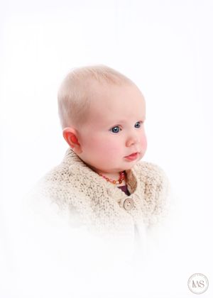 Close-up portrait with delicate lace details against white background.