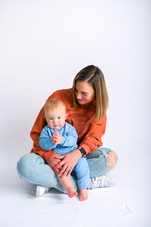 Sweet bonding moment captured in studio with light blue and orange color palette.