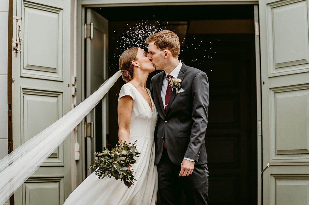 Bröllopspar gratuleras på trappan till Rogerga kyrka, efter vigseln. Bröllopsfotograf Veronica Eng fotade bröllopet.