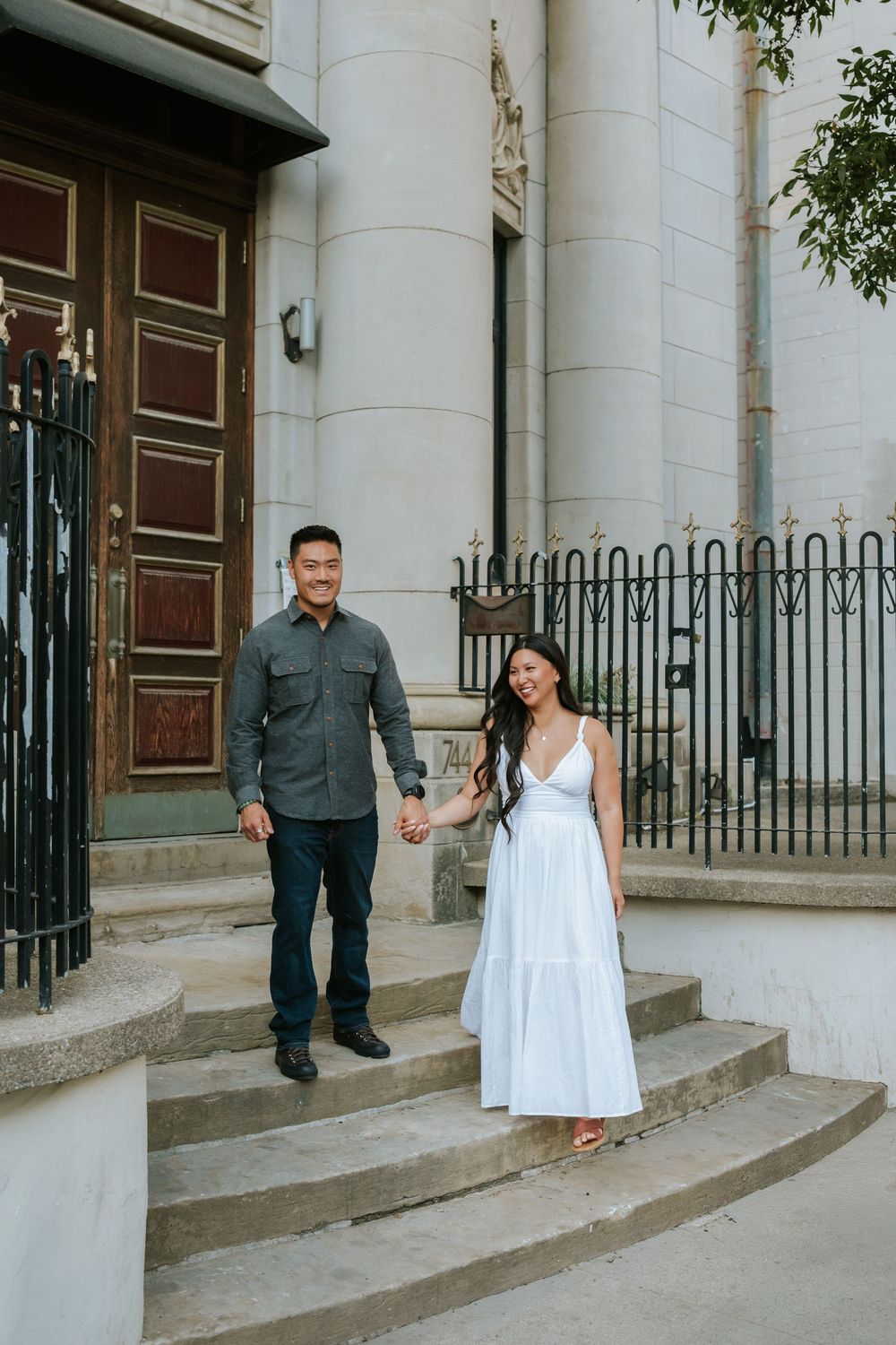 A series of four photos showing a couple posing on stone steps in front of a historic building with white columns.