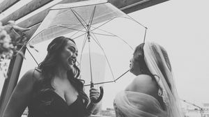 Wedding party poses with white umbrellas in an artistic black and white photo series.