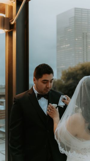 An emotional wedding moment captured on a rooftop terrace with urban skyline views.
