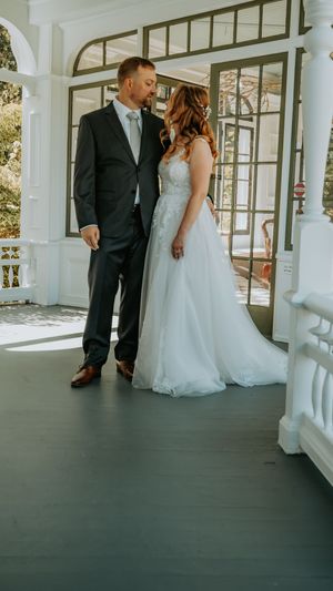A romantic wedding couple shares intimate moments on an elegant white porch with columns.