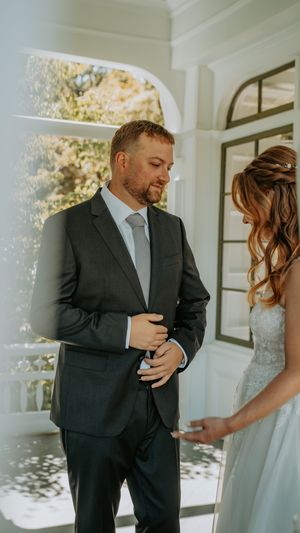 A couple shares an intimate moment during their first look on their wedding day.