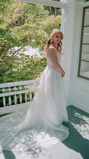 An elegant bridal portrait series on a white porch with a flowing wedding gown creating graceful movement.