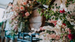Elegant floral installation with blush pink roses and white blooms cascades across a light-colored wall.
