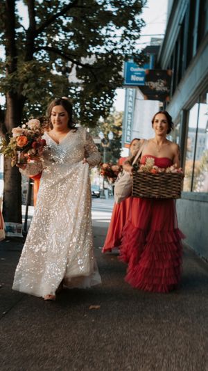 A bridal party in red dresses and sparkly gowns poses in a series of candid outdoor photos at dusk.