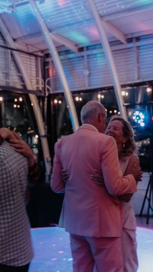 Couples dancing together on an illuminated dance floor with blue and pink lighting effects.