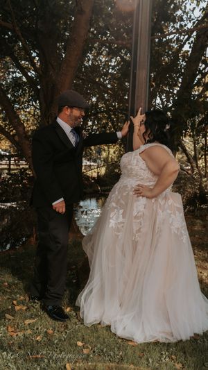 A romantic outdoor wedding moment captured among trees during golden hour.