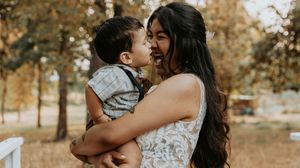 Romantic autumn photo session in a park with warm golden leaves and sunlight filtering through the trees.