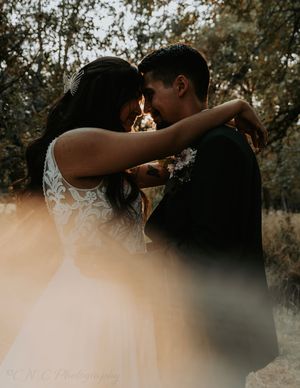 An intimate wedding moment captured in a dreamy outdoor setting with natural lighting.