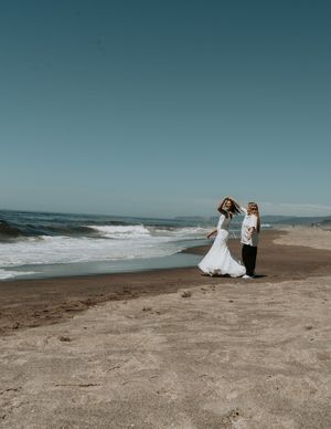 A romantic beach wedding scene with waves crashing in the background.