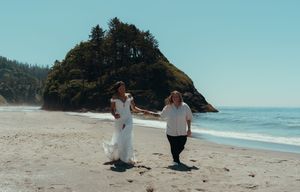 Couple walking along scenic Oregon coastline with dramatic cliffs and ocean views in summer.