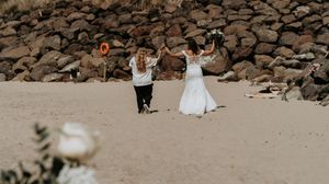 Distant view of people walking along a rocky beach shoreline.