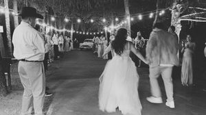 String lights illuminate an outdoor evening wedding reception creating a romantic ambiance.