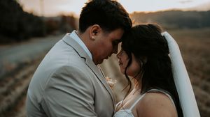 Intimate wedding portrait captured at sunset against a mountain backdrop.