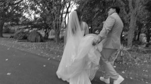 Black and white panoramic shot of wedding guests gathering at an outdoor reception.