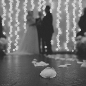 Hanging string lights create a romantic bokeh effect against a dark background.
