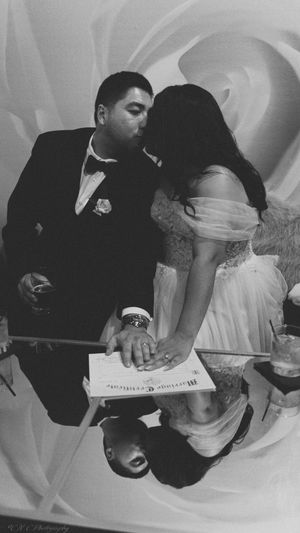 Black and white wedding photo sequence showing couple signing marriage documents at ceremony.