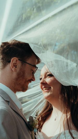 A romantic wedding moment captured through a delicate veil, creating an ethereal and intimate atmosphere.