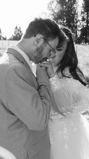 A romantic black and white photo sequence showing a couple sharing a tender kiss in a natural outdoor setting.