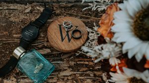 Rustic flat lay with daisies, vintage mason jars, and wooden elements against dark textured background.