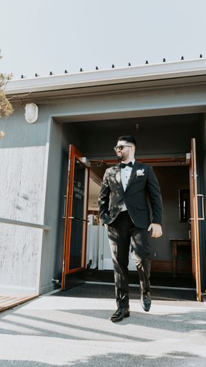 Sequence of a person in a suit emerging dramatically from a modern doorway.