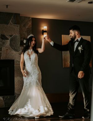 A couple dances together in a dimly lit venue during their wedding celebration.