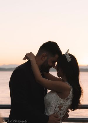 Romantic sunset silhouettes on a waterfront with elegant wedding attire.