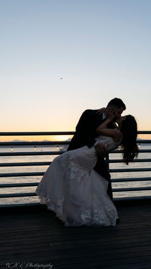 Dramatic dip pose sequence on a waterfront pier at sunset.