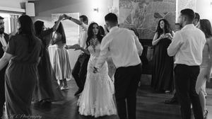 Black and white panoramic photo of couples dancing together in a ballroom dance class.