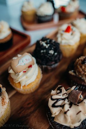 Close-up view of gourmet appetizers with cream toppings and garnishes arranged on a rustic wooden serving board.
