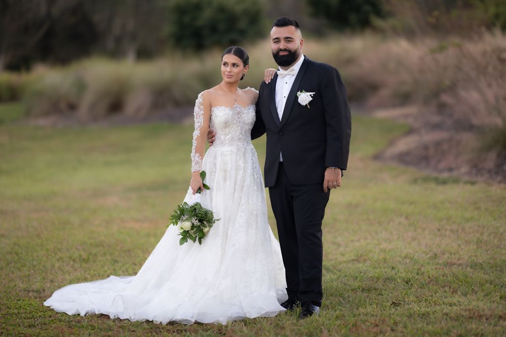 Couple getting their wedding picture taken. Bride is holding her flowers while picture is taken.