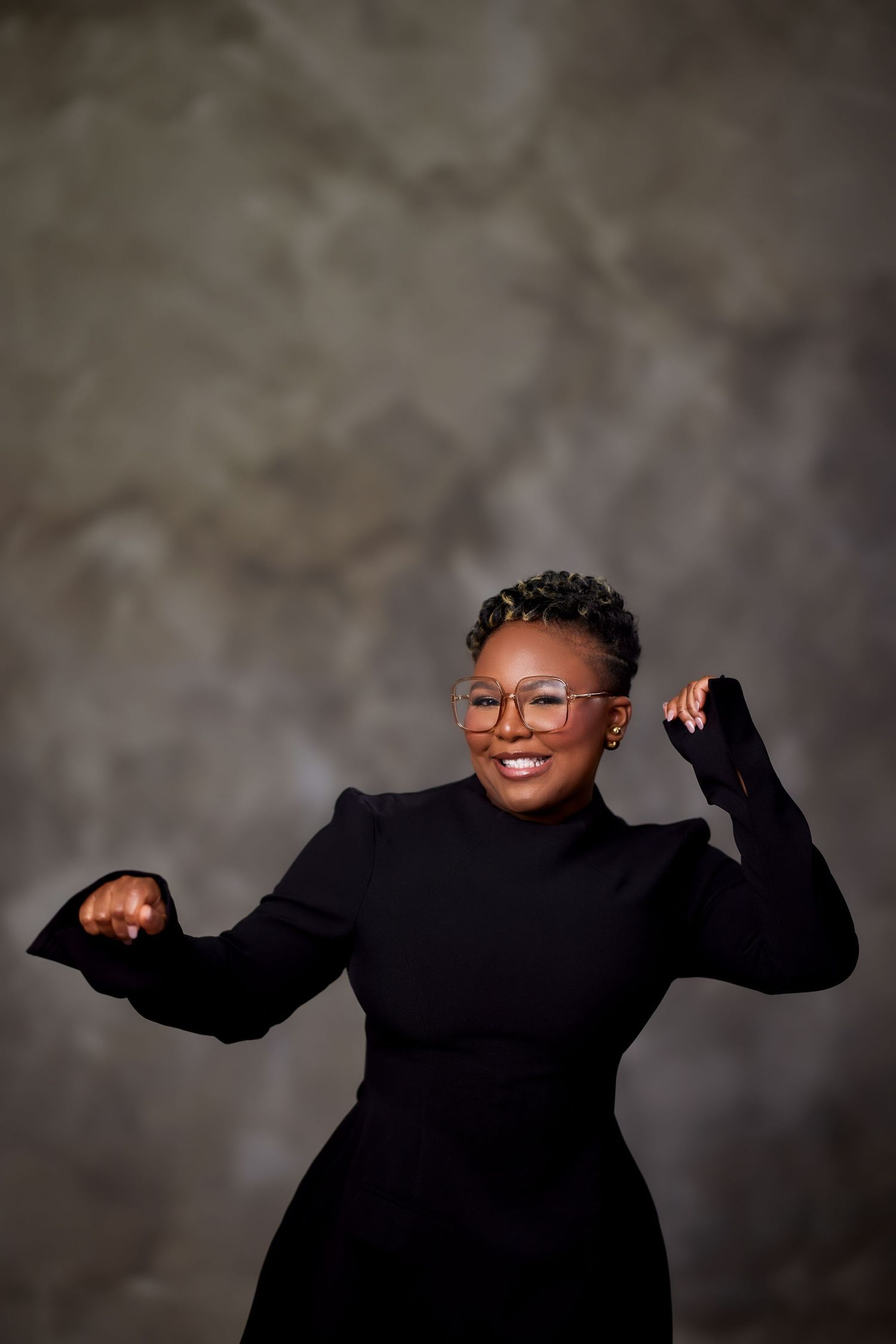 A series of five expressive poses in a black sweater against a gray backdrop shows joyful movement and energy.