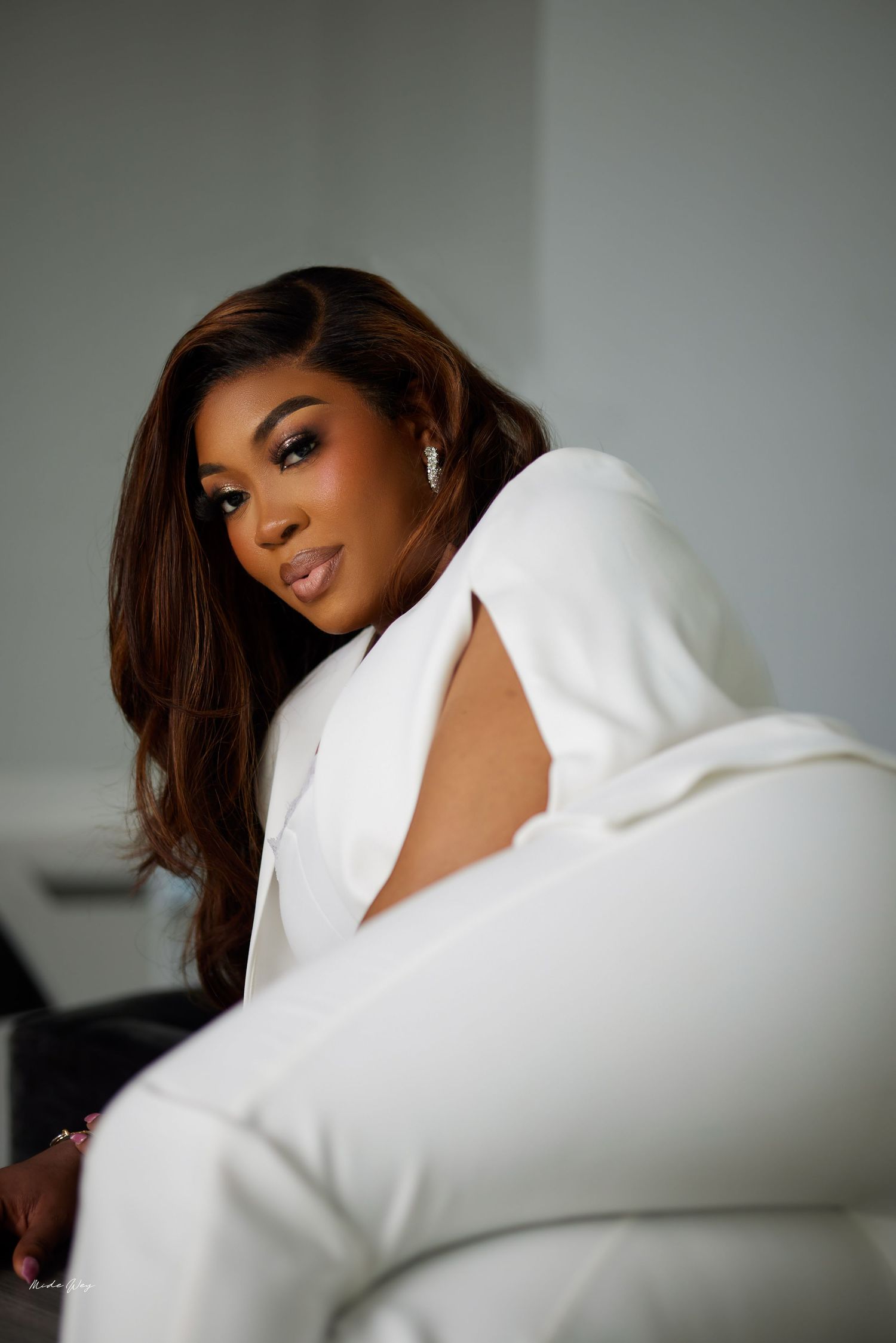A glamorous portrait series in white against a neutral background showcasing elegant poses and styling.