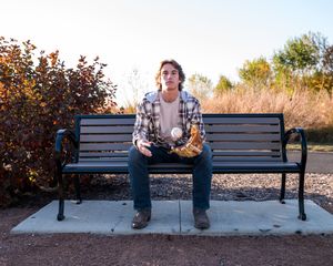 A sequence of images showing someone sitting on a park bench in different poses during autumn.