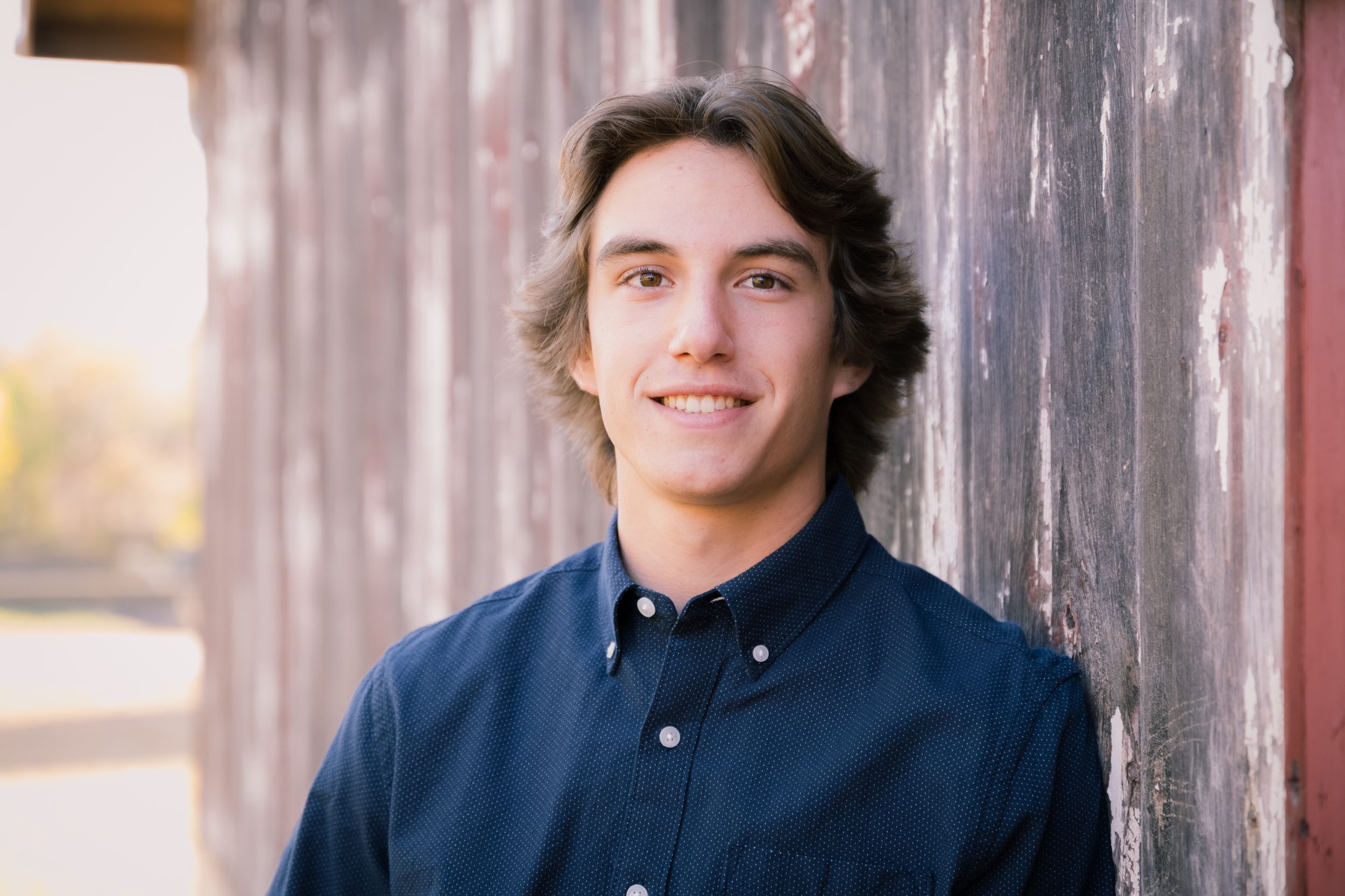Four casual portraits against a rustic wooden wall background in natural lighting.