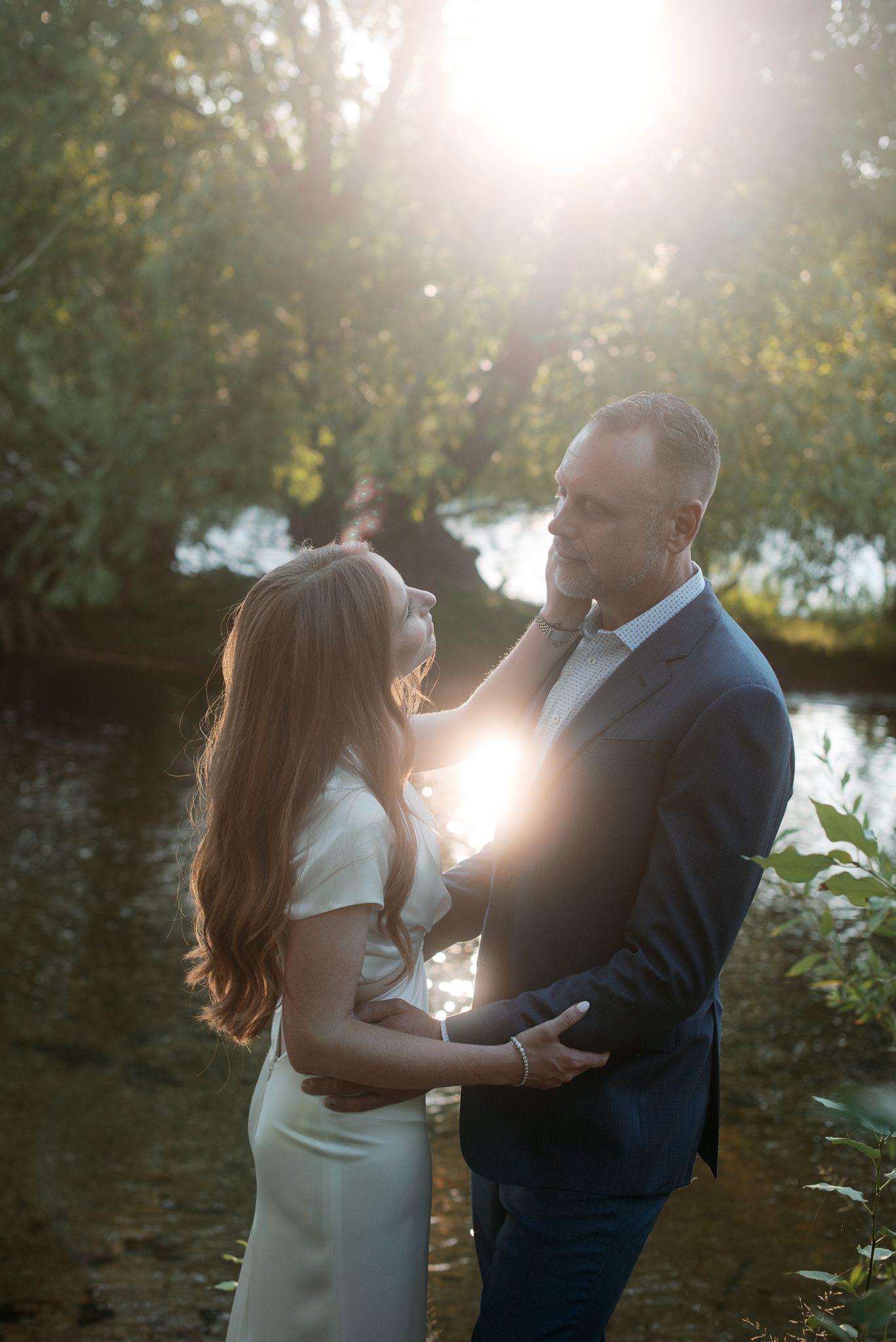 a bride and a groom at the greenbelt near the river in boise posing for their wedding photos