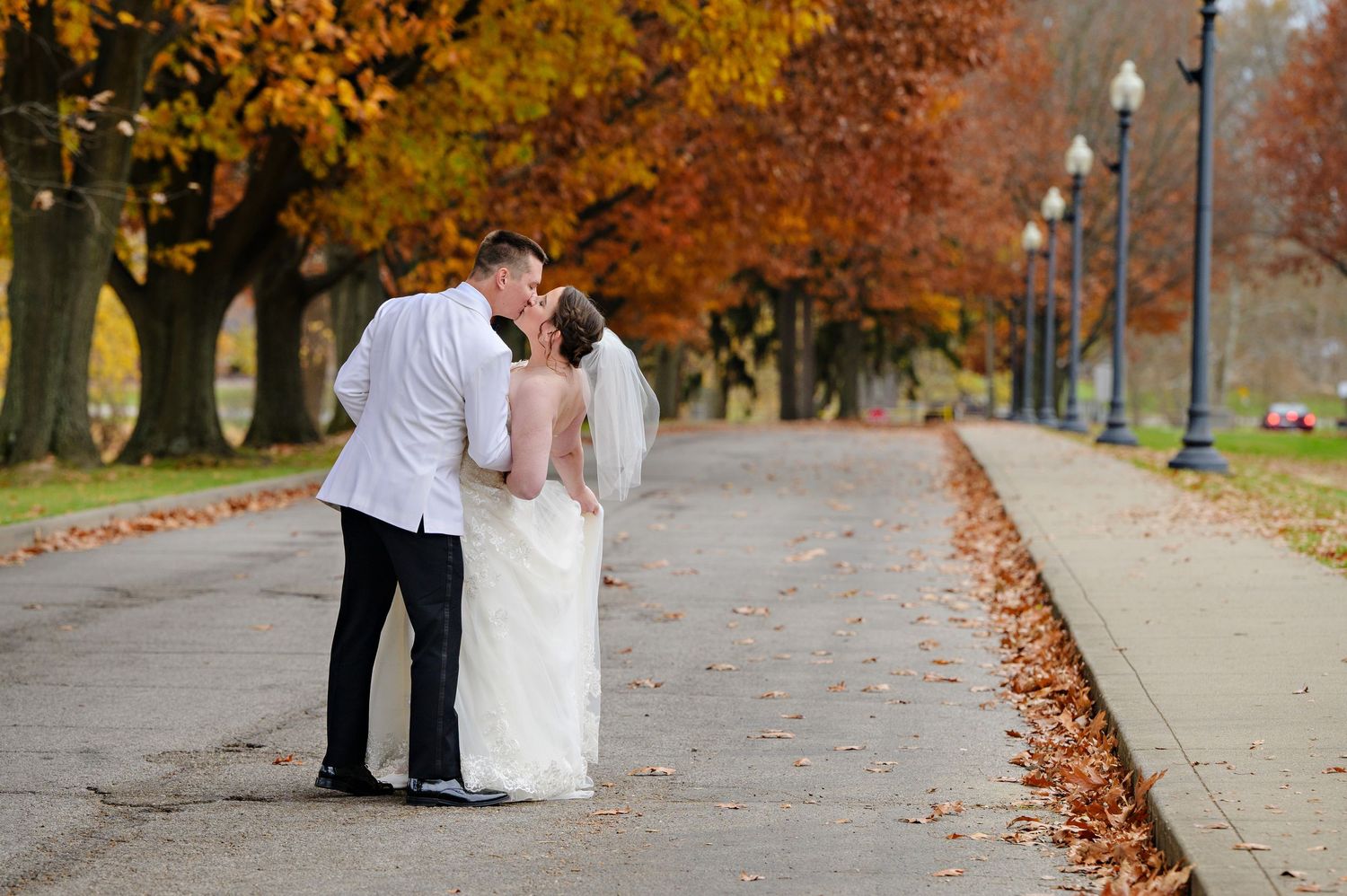 Bride and Groom kissing beneath the autumn trees after their Canton Wedding Ceremony at McKinley Monument Park in Canton Ohio in November