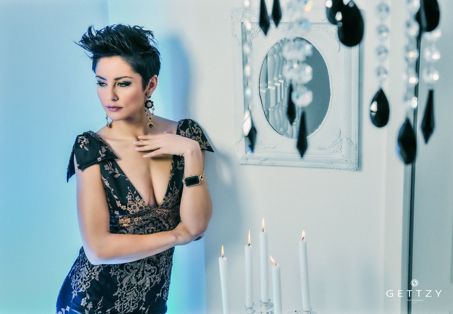 Moody portrait with candlelight featuring a black lace dress and dramatic lighting.