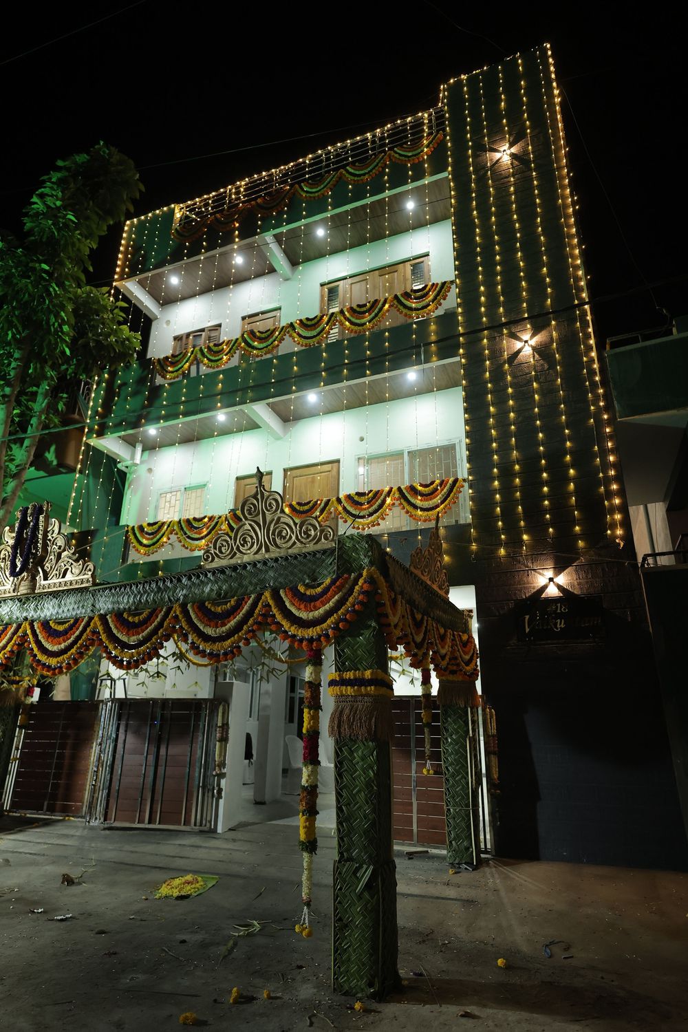Colorful Indian building decorated with lights and marigold garlands at night for a festive celebration.