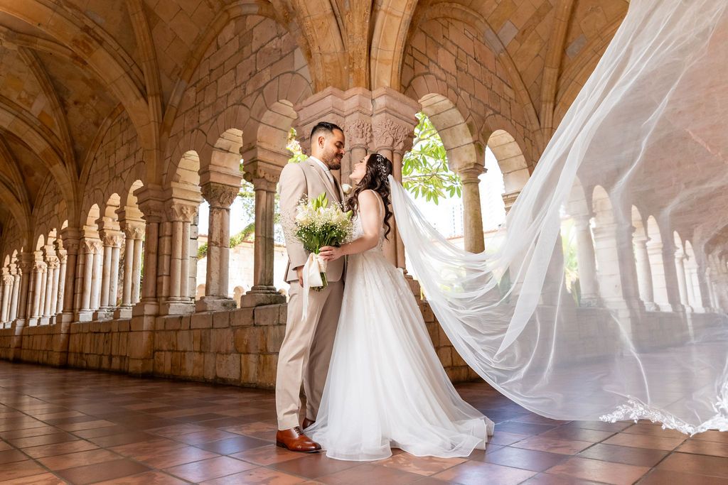 Bride and groom sharing a wedding portrait in the cloister of The Ancient Spanish Monastery in Miami.