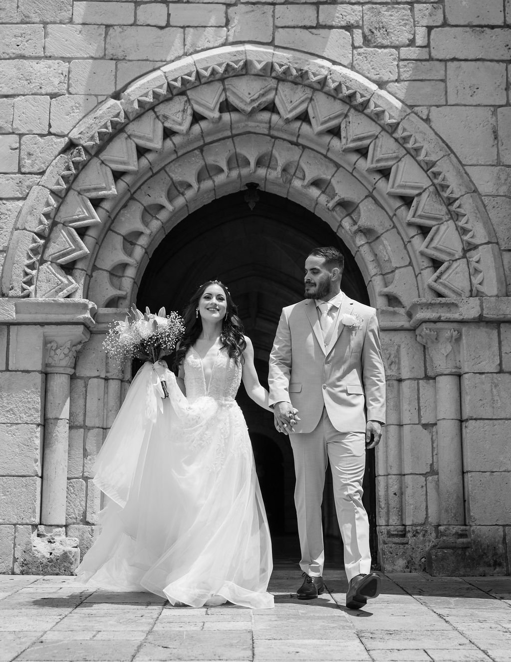 Bride and groom walking from The Ancient Spanish Monastery after their wedding ceremony in Miami. Photo by Manuel Okata. OkataStudio
