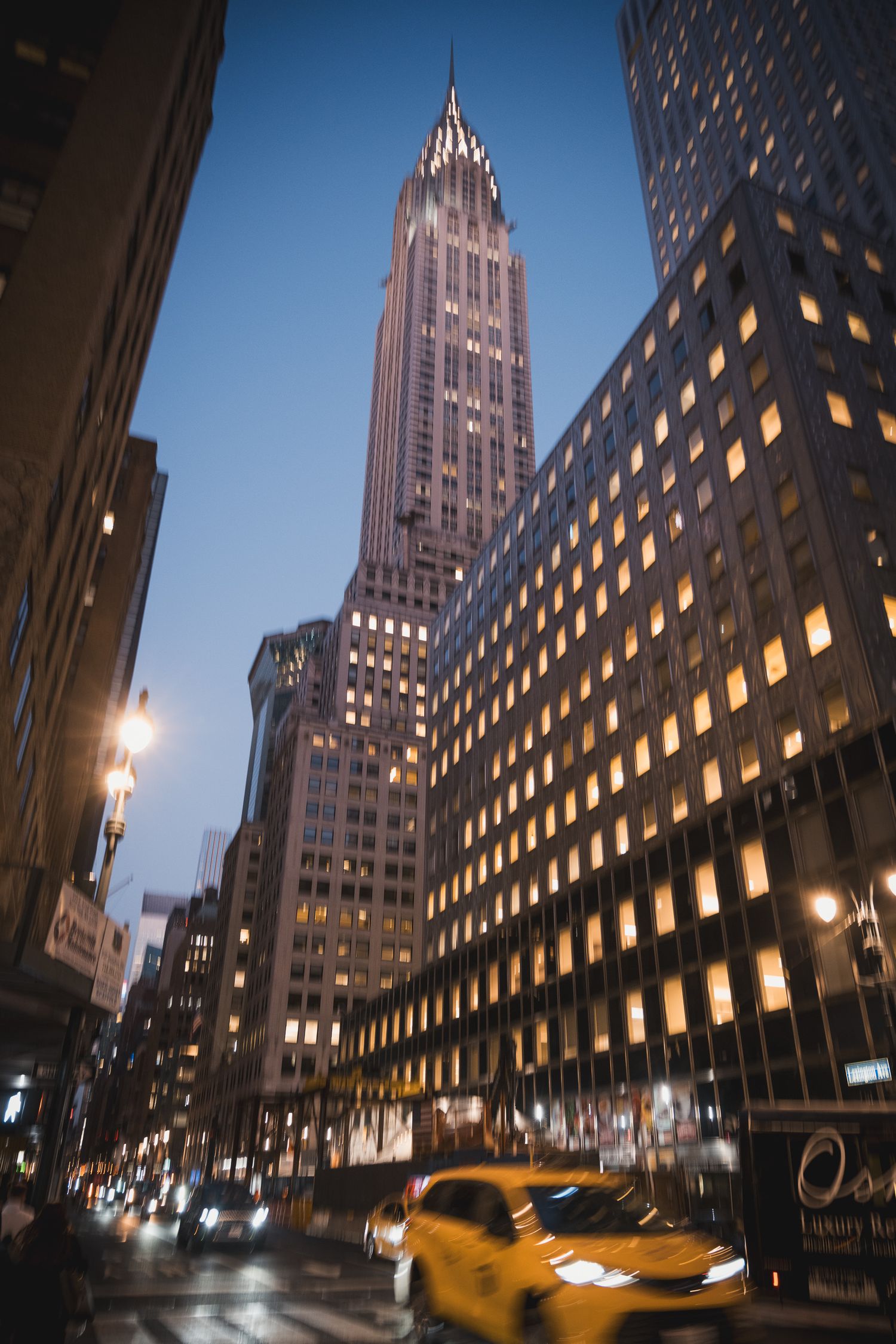 Chrysler Building illuminato di notte visto dalla strada tra i grattacieli